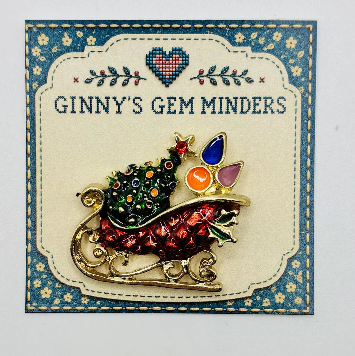 Enamel crystal sled needle minder on Ginny’s Gem Minders display card