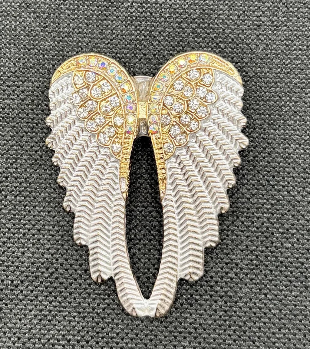 White enamel and crystal angel wings needle minder on dark fabric