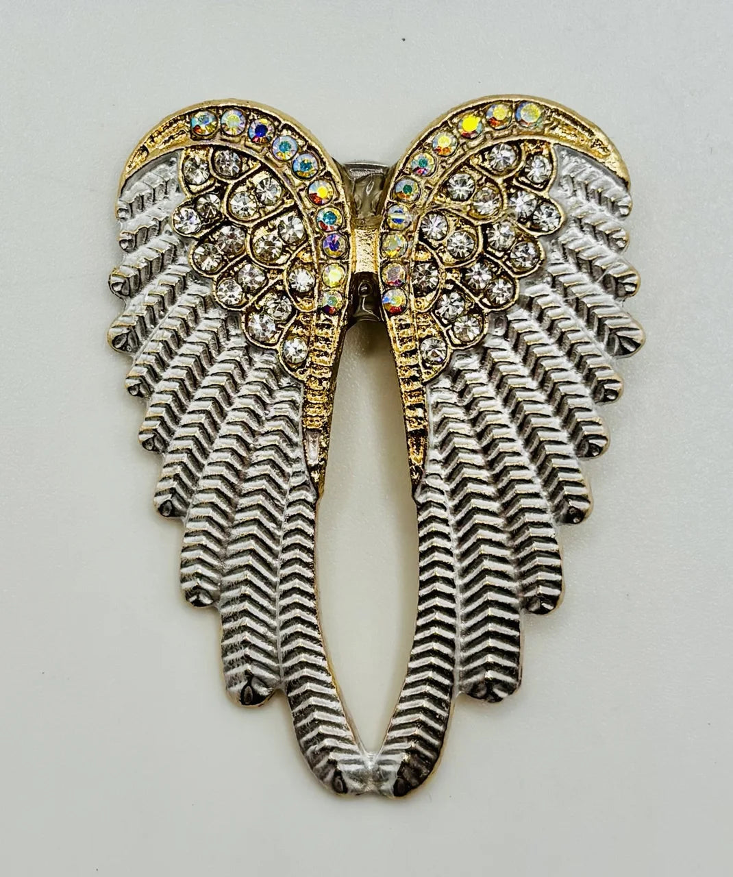 White enamel and crystal angel wings needle minder on a white background