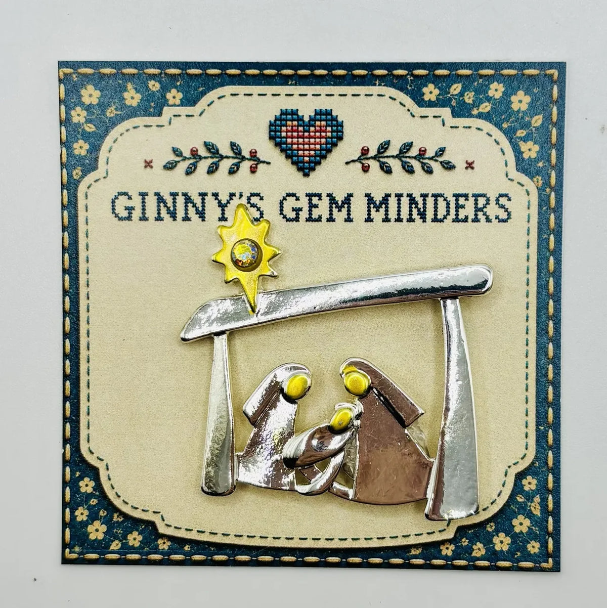 Silver and gold metal Holy Family needle minder on Ginny’s Gem Minders display card