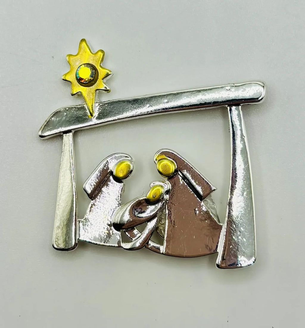 Silver and gold metal Holy Family needle minder on a white background