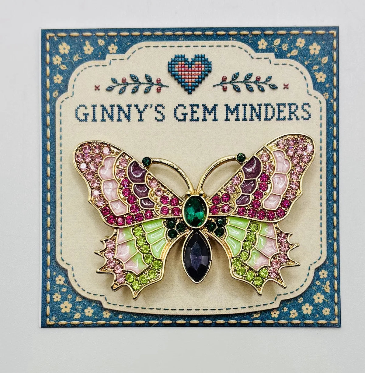 Red white and pink and green enamel crystal butterfly needle minder on Ginny’s Gem Minders display card