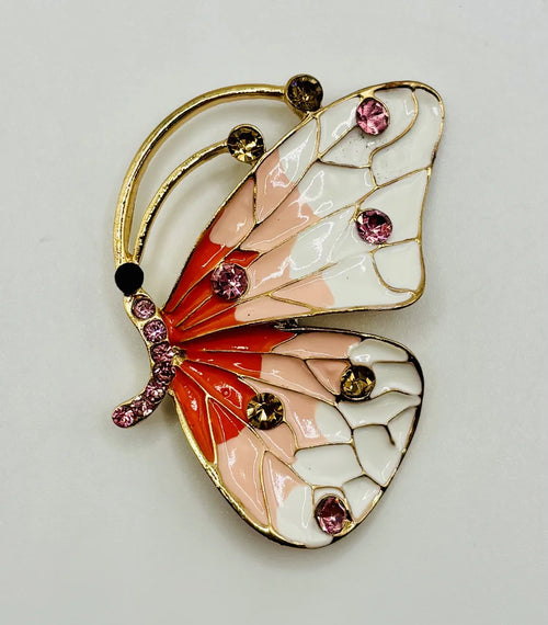 Red white and peach and white enamel and crystal butterfly needle minder on a white background