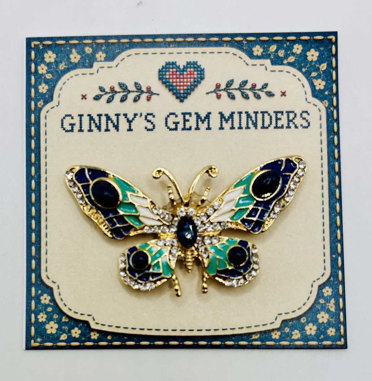 Red white and small blue green and white enamel crystal butterfly needle minder on Ginny’s Gem Minders display card