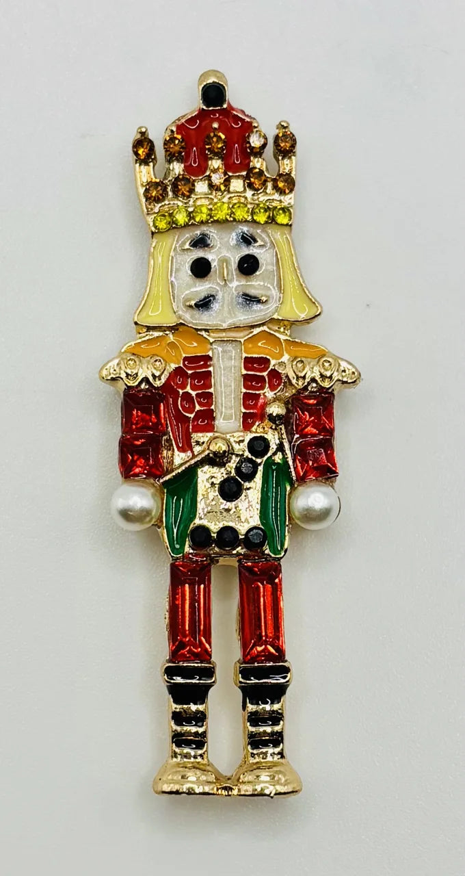 Green and red crystal nutcracker needle minder on a white background