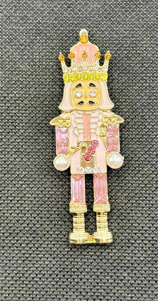 Pink crystal nutcracker needle minder on dark fabric