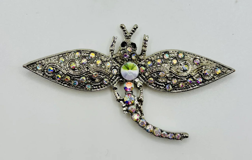 Silver and crystal dragonfly needle minder on a white background