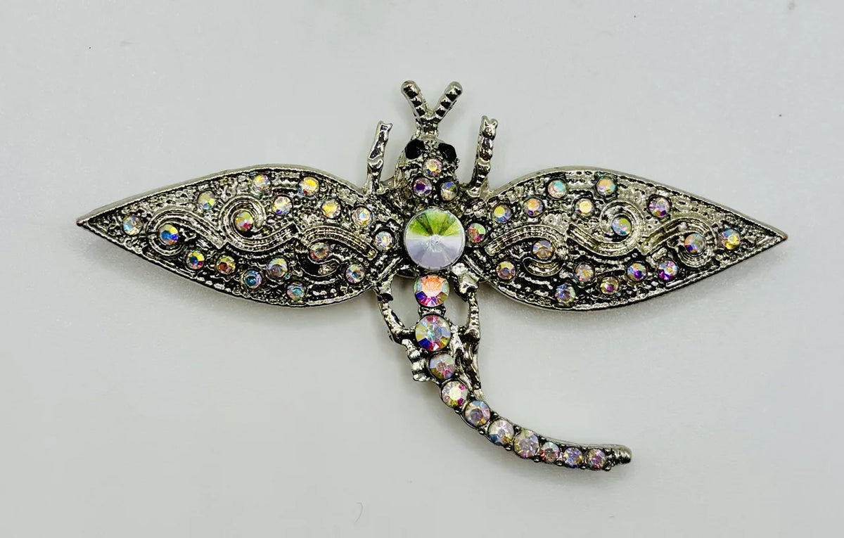 Silver and crystal dragonfly needle minder on a white background