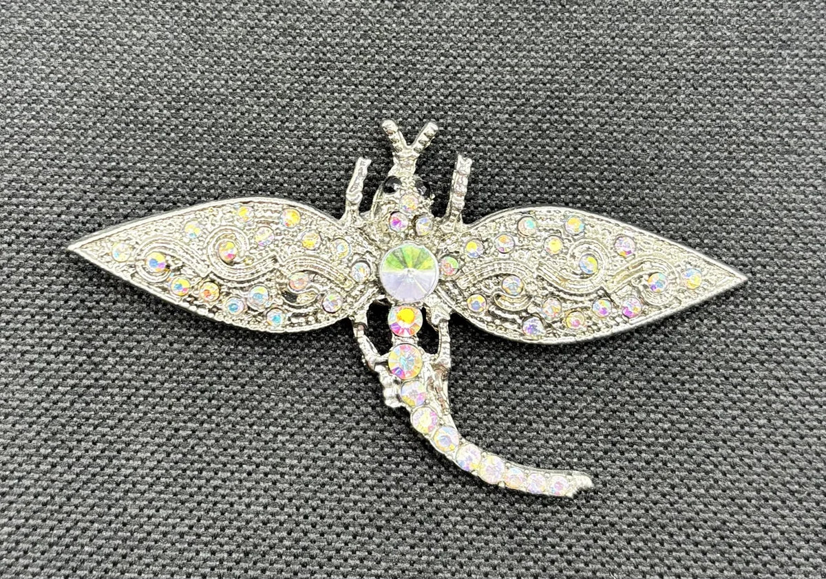 Silver and crystal dragonfly needle minder on dark fabric