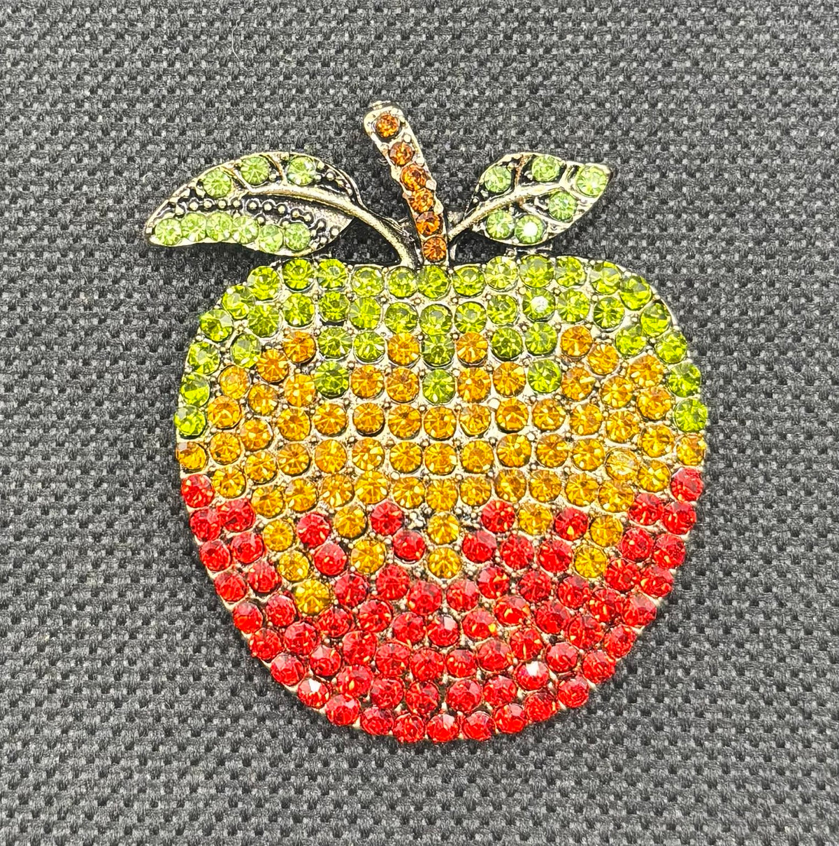 Crystal apple needle minder on dark fabric