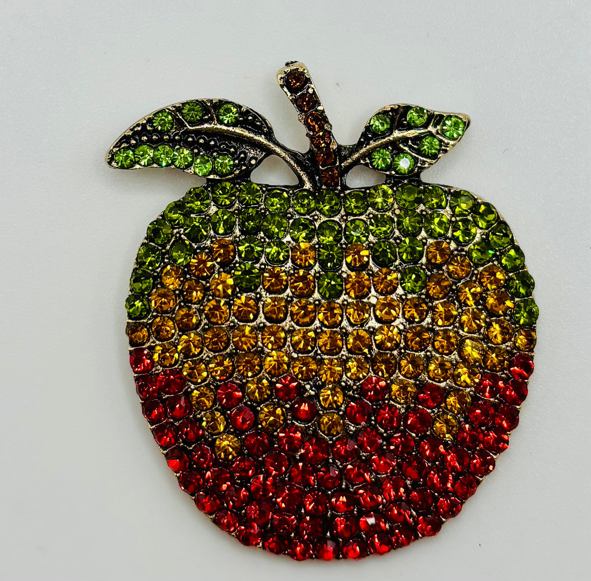 Crystal apple needle minder on a white background