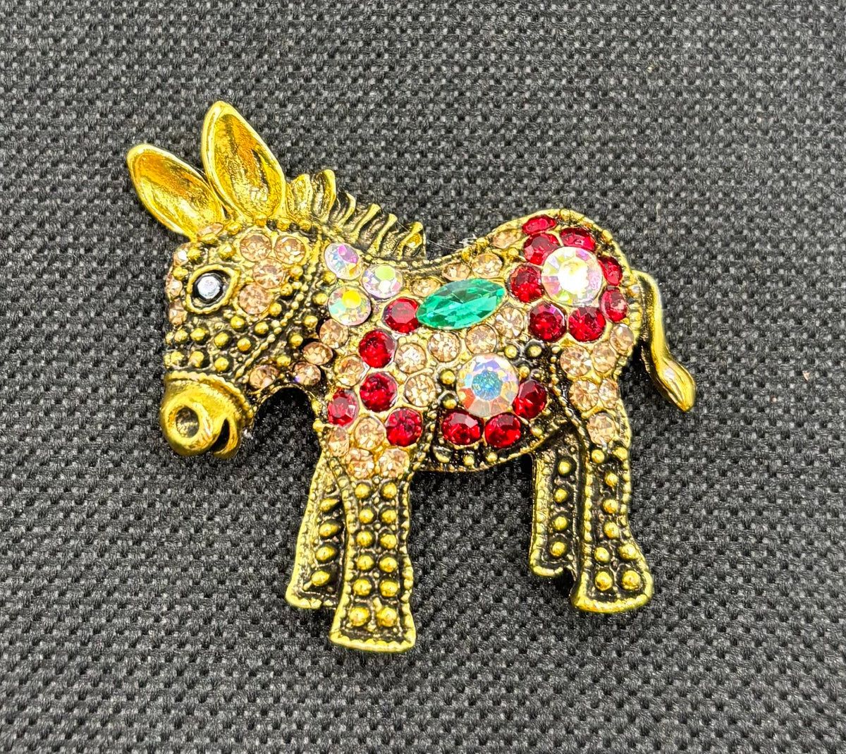 Colorful Crystal and Gold Donkey Needle Minder on dark fabric