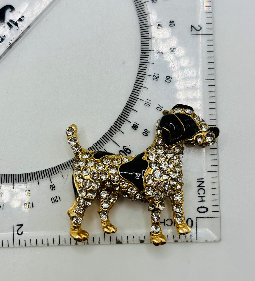 Black and crystal spotted dog needle minder beside a ruler for scale