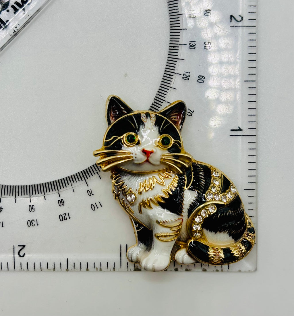 Black and white cat kitty needle minder beside a ruler for scale