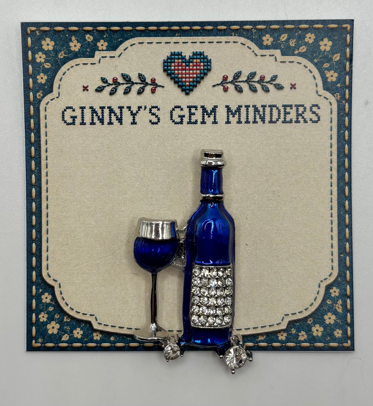 Small Blue Enamel Wine Bottle and Glass Needle Minder — display card