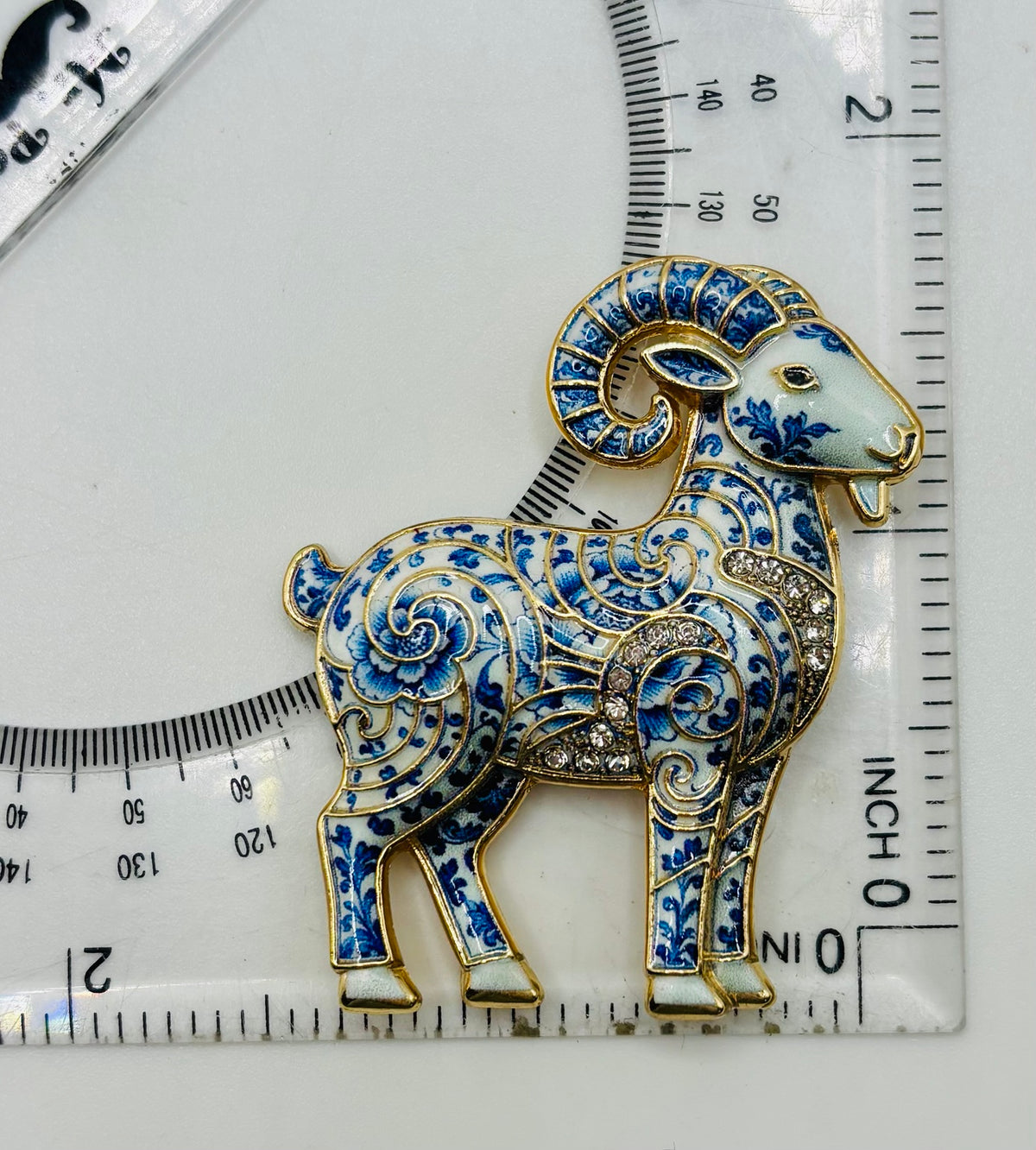Blue white ram needle minder beside ruler for scale