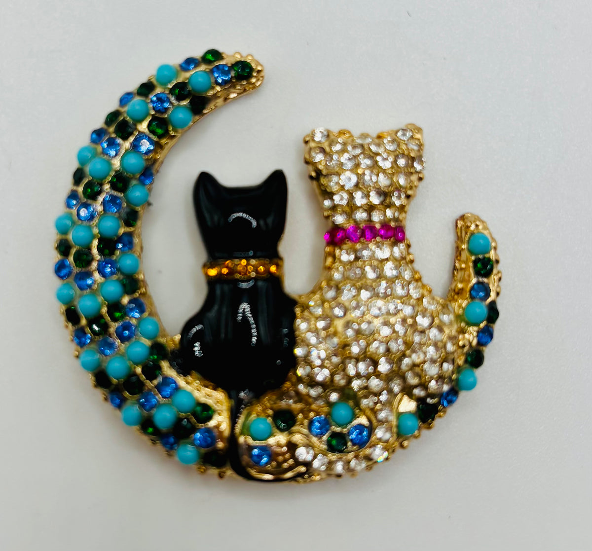 Black and crystal cats on turquoise moon needle minder on white background