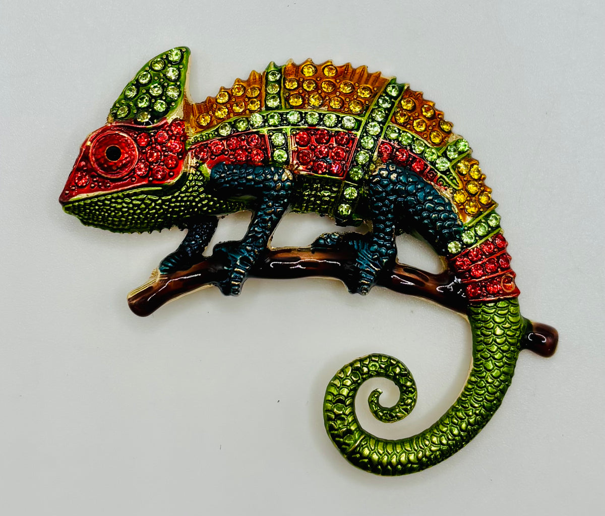 Colorful crystal chameleon needle minder on white background
