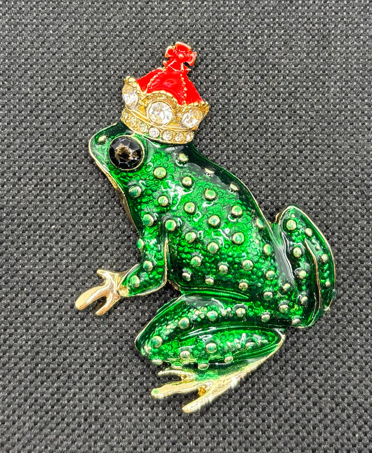 Dark green frog king needle minder on dark fabric