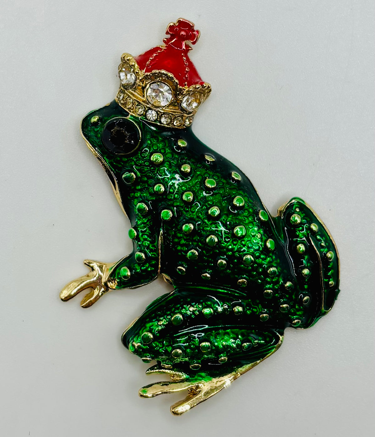 Dark green frog king needle minder on white background