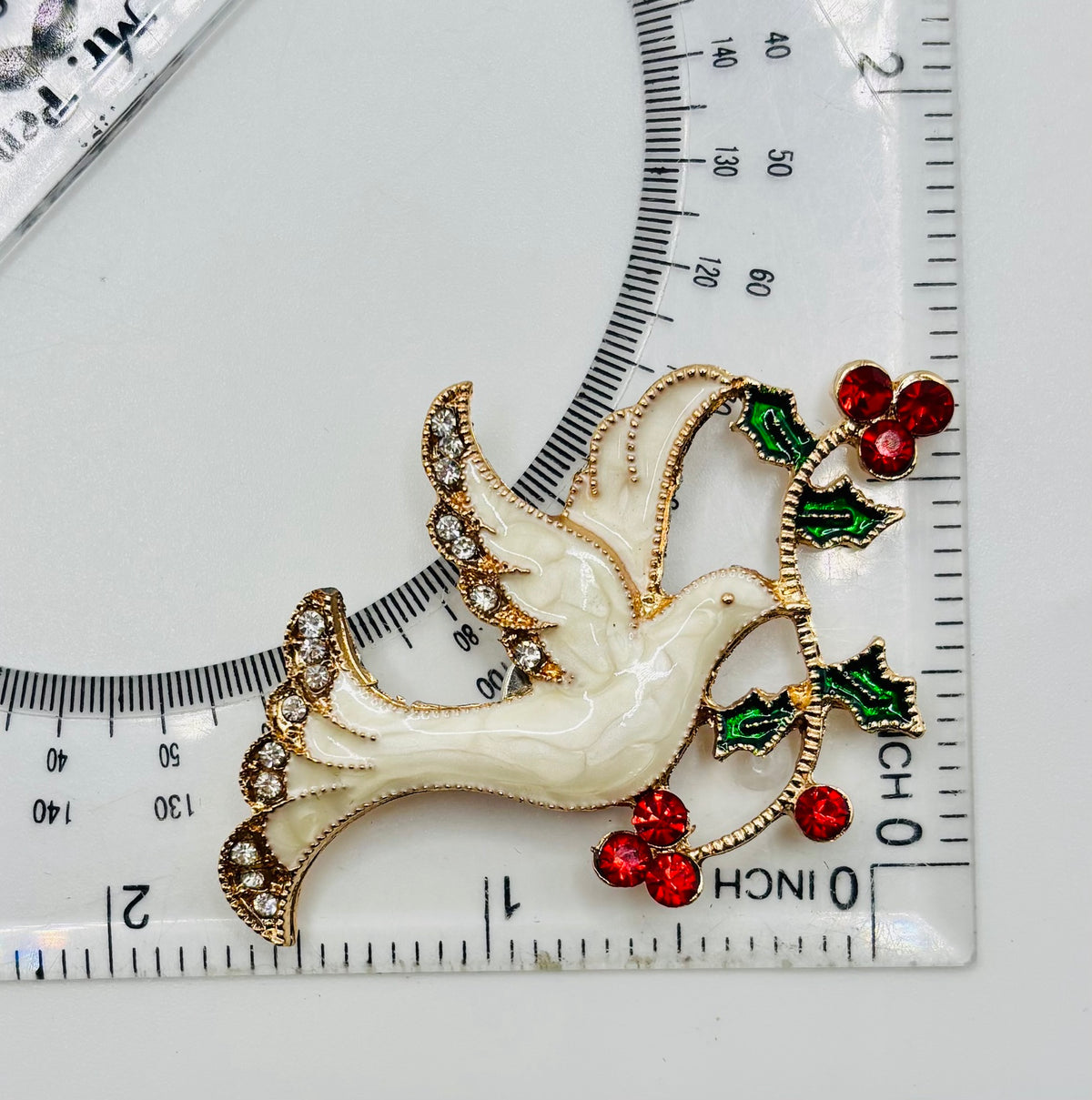 Enamel dove with red crystal branch needle minder — ruler scale