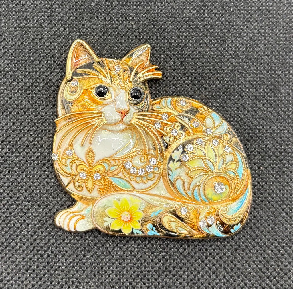 Floral crystal cat needle minder on dark fabric