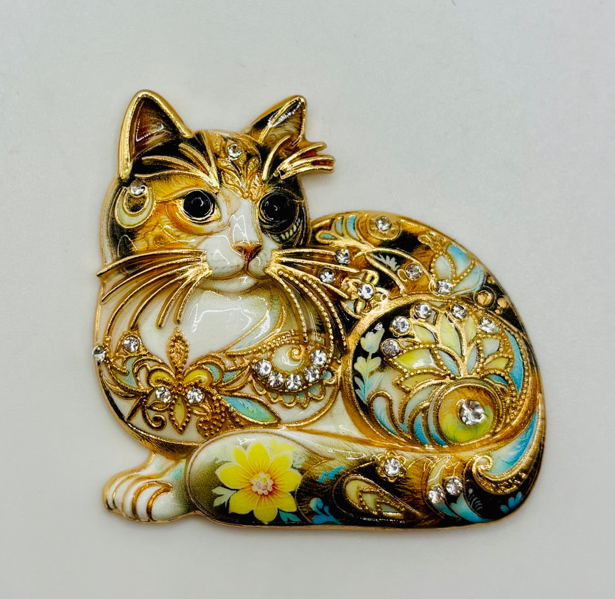 Floral crystal cat needle minder on white background