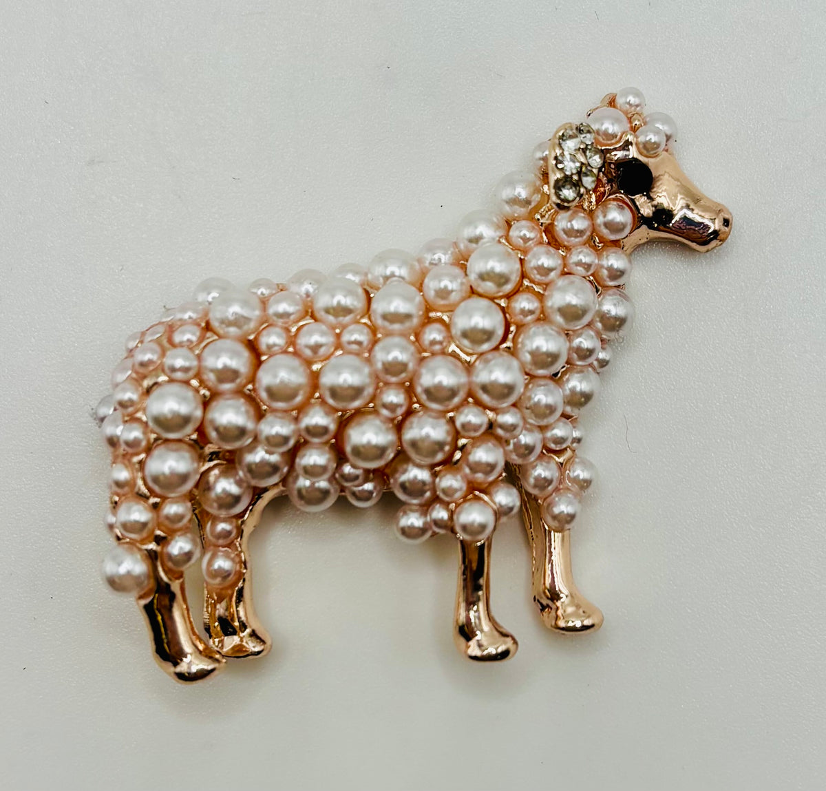 Fluffy pearl sheep needle minder on white background