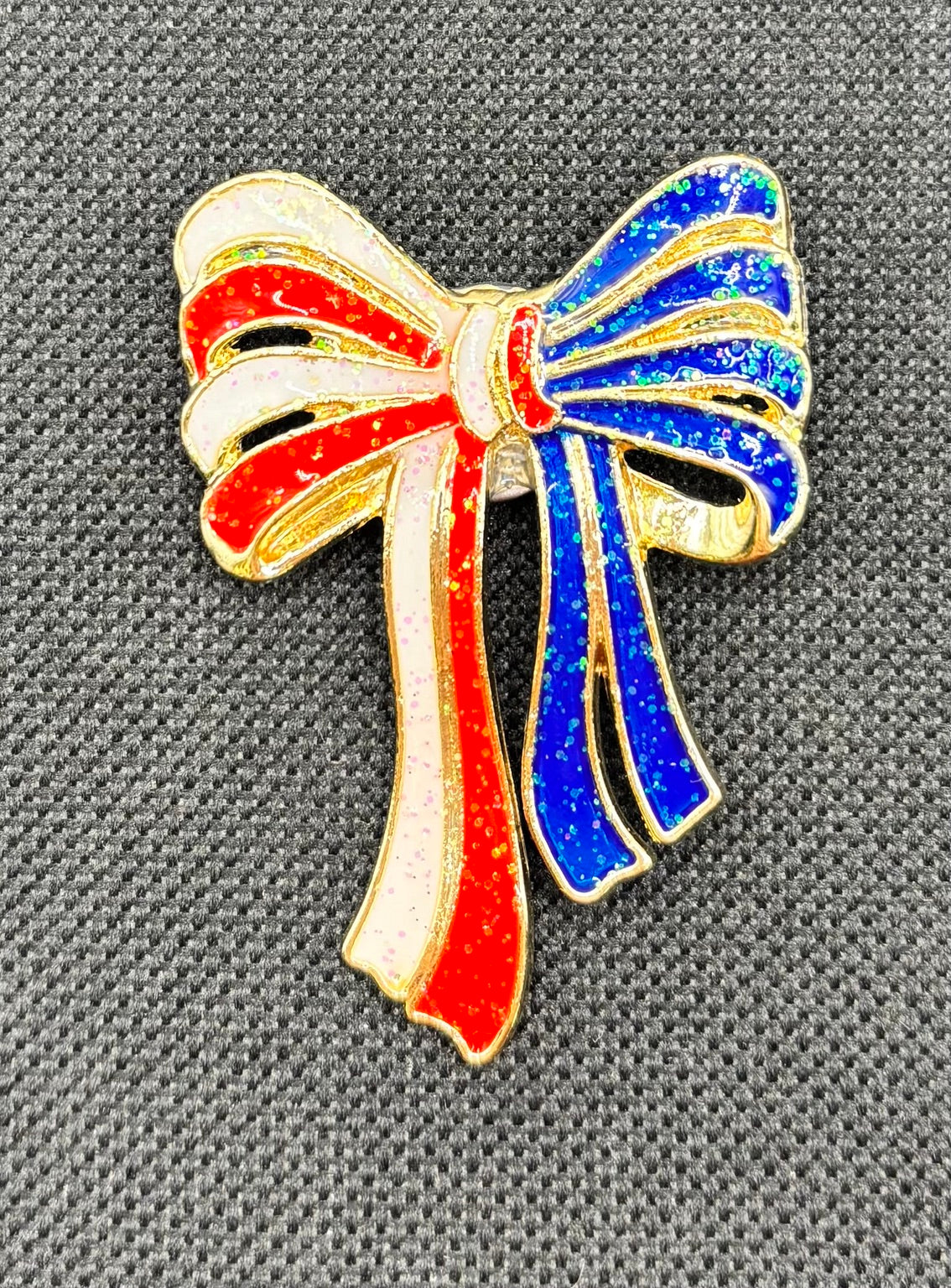 Glittery Red, White, Blue Enamel Bow Needle Minder — dark fabric