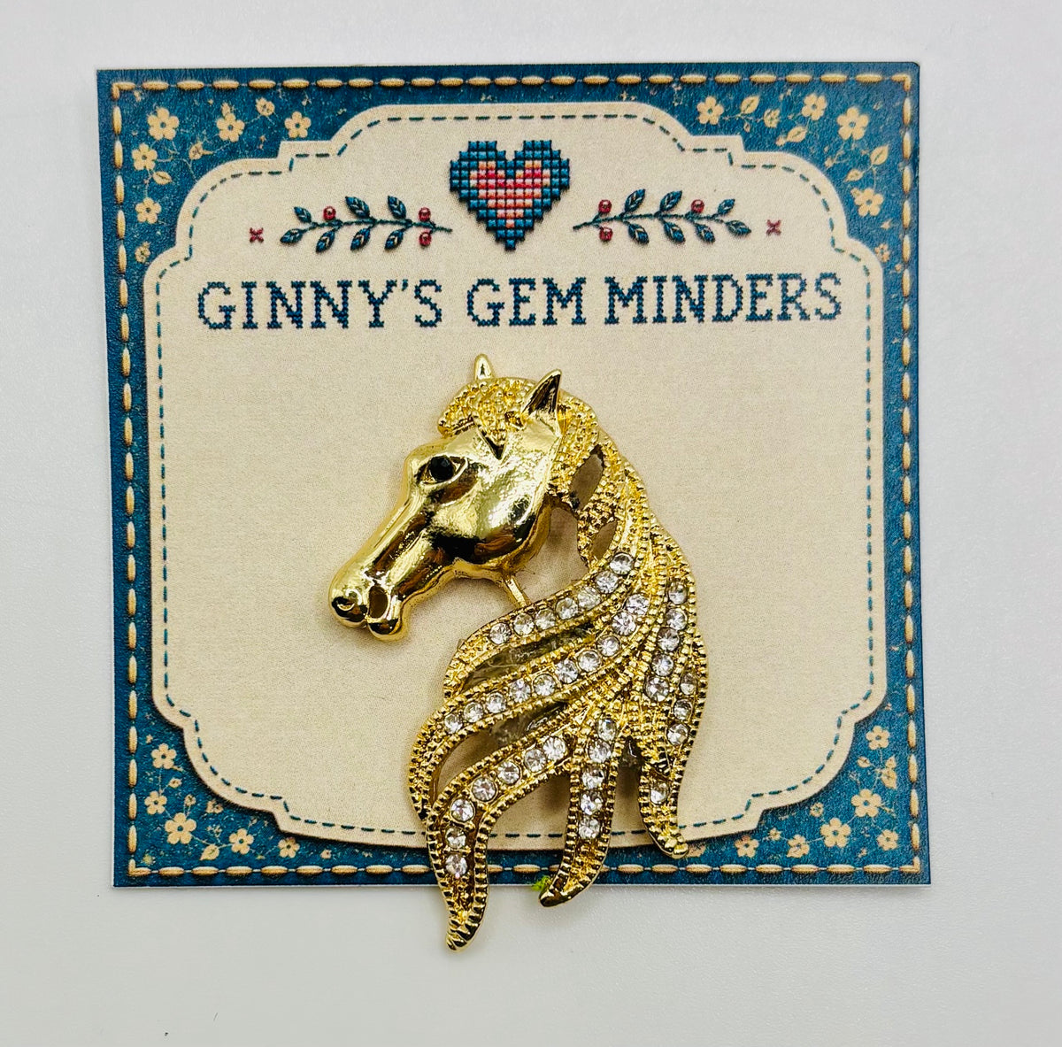 Gold and crystal horse head needle minder on display card
