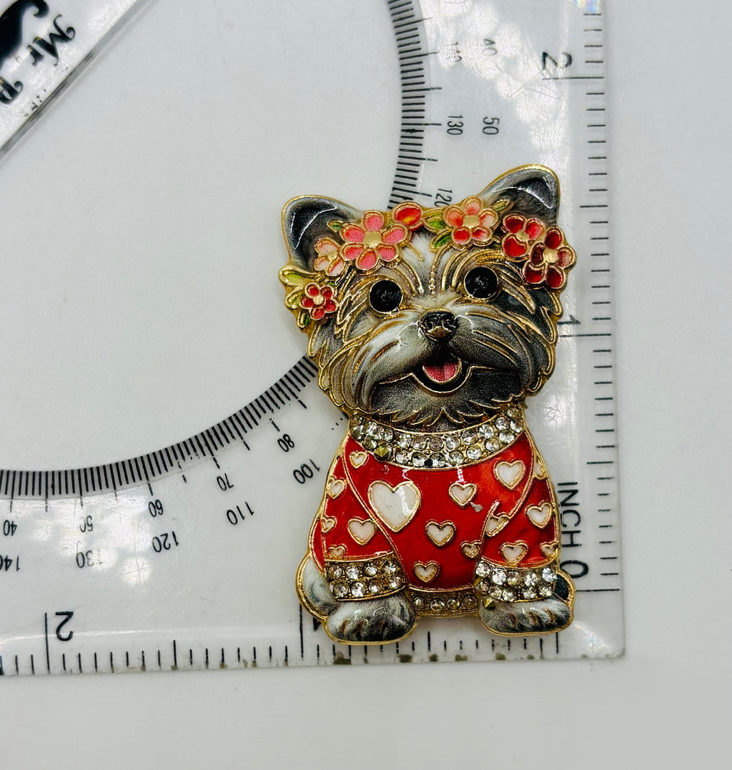 Gray dog in red heart sweater needle minder beside a ruler for scale