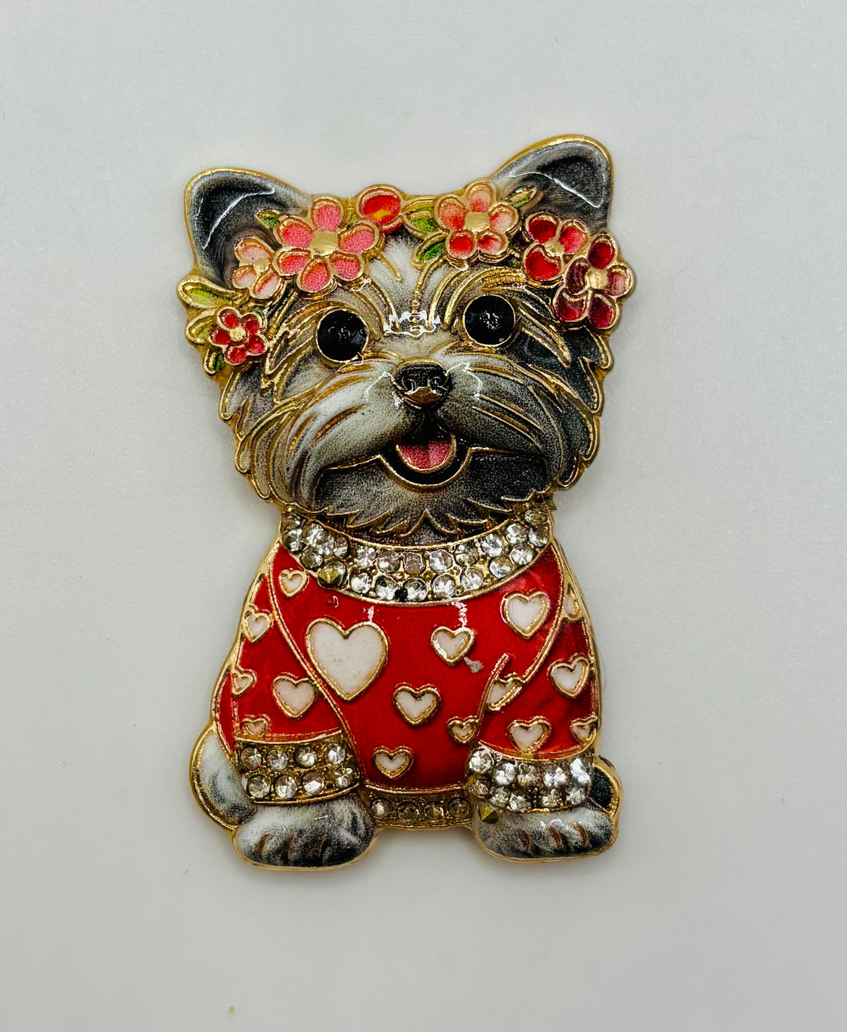 Gray dog in red heart sweater needle minder on white background