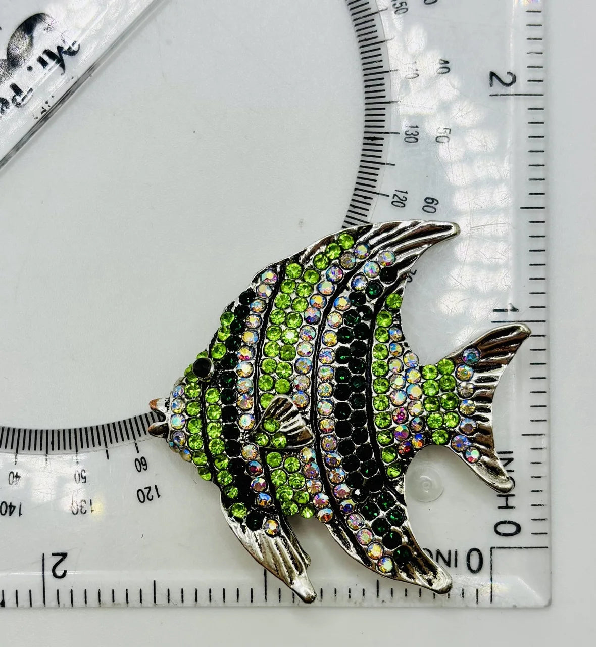 Green crystal angelfish needle minder beside a ruler for scale