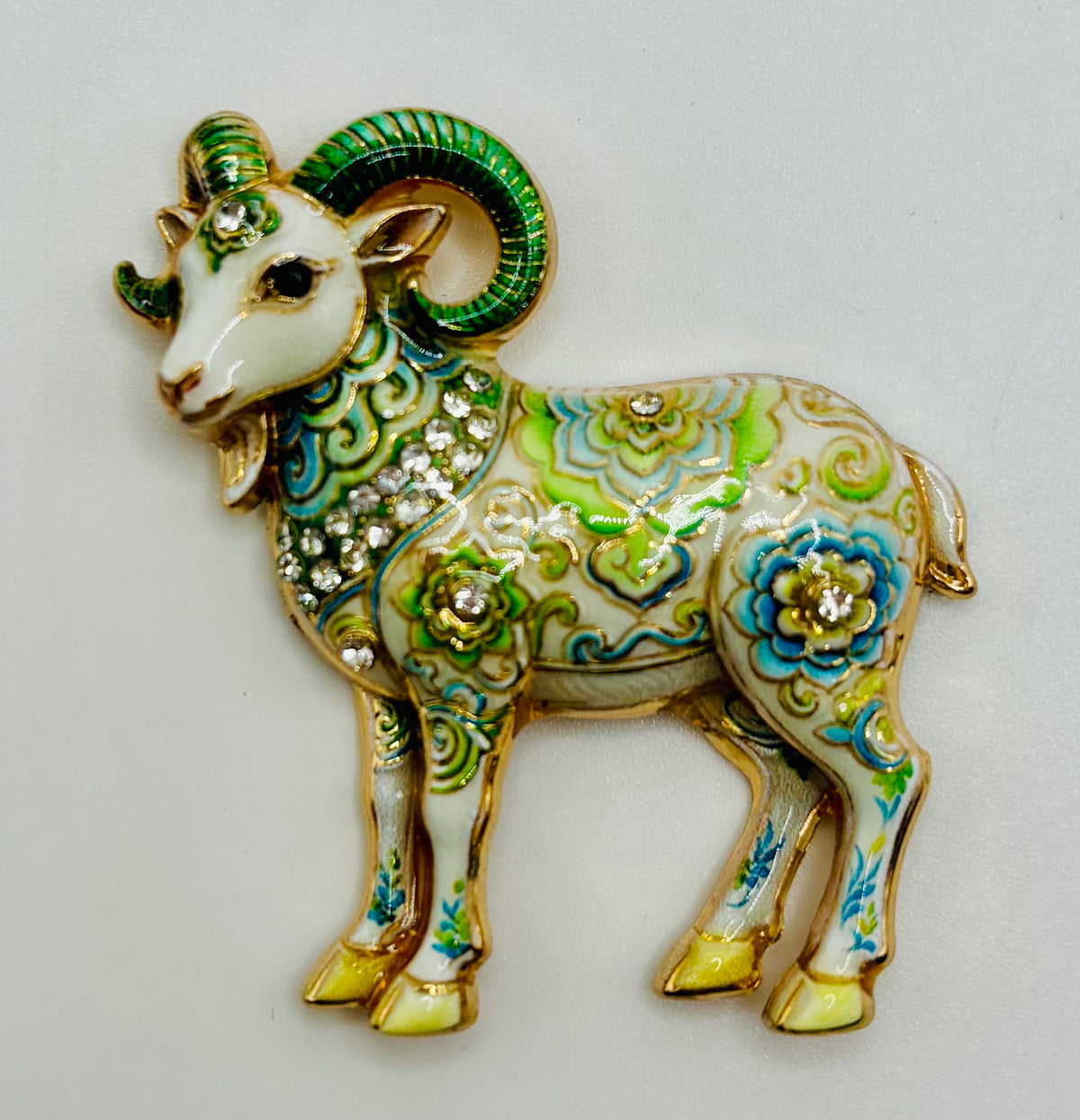 Green floral goat needle minder on white background