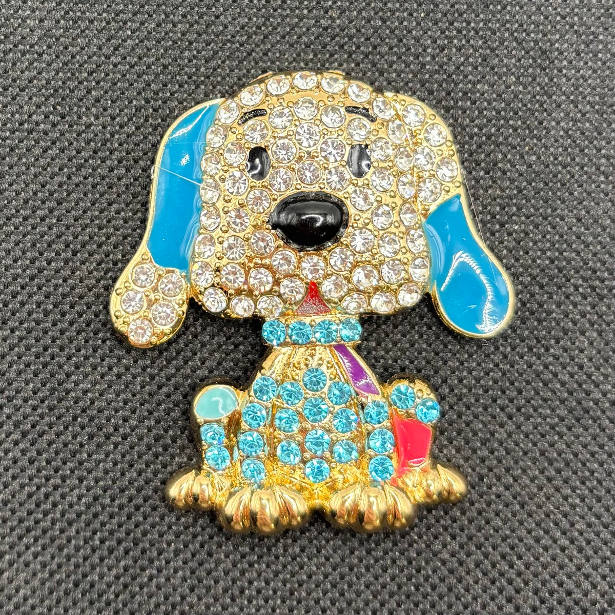 Large blue crystal dog needle minder on dark fabric