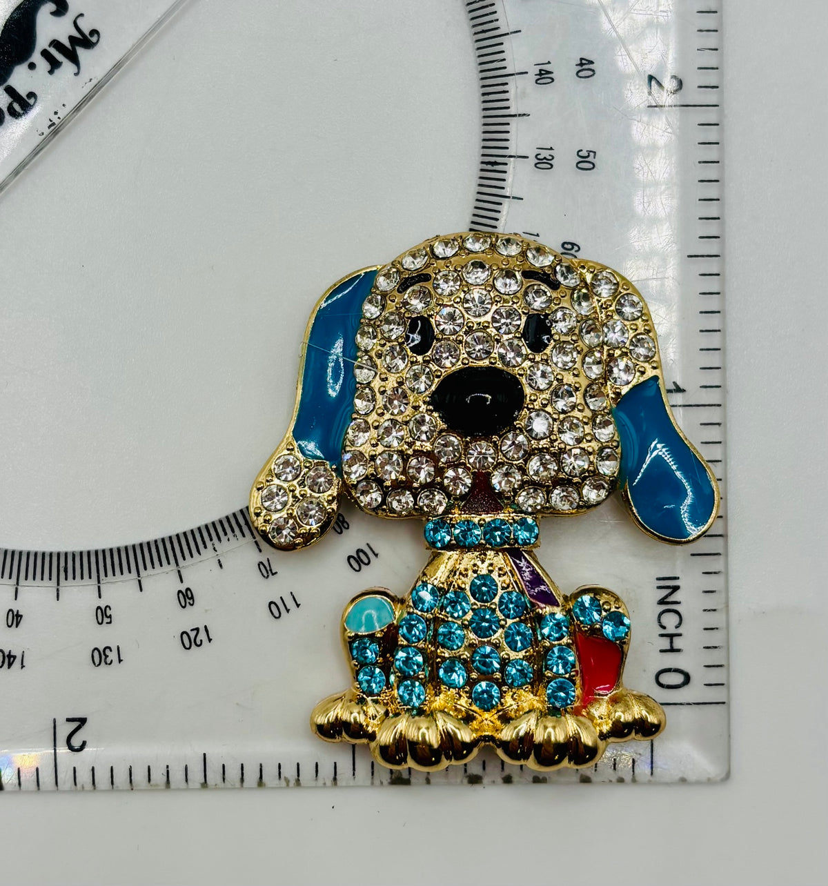 Large blue crystal dog needle minder beside a ruler for scale