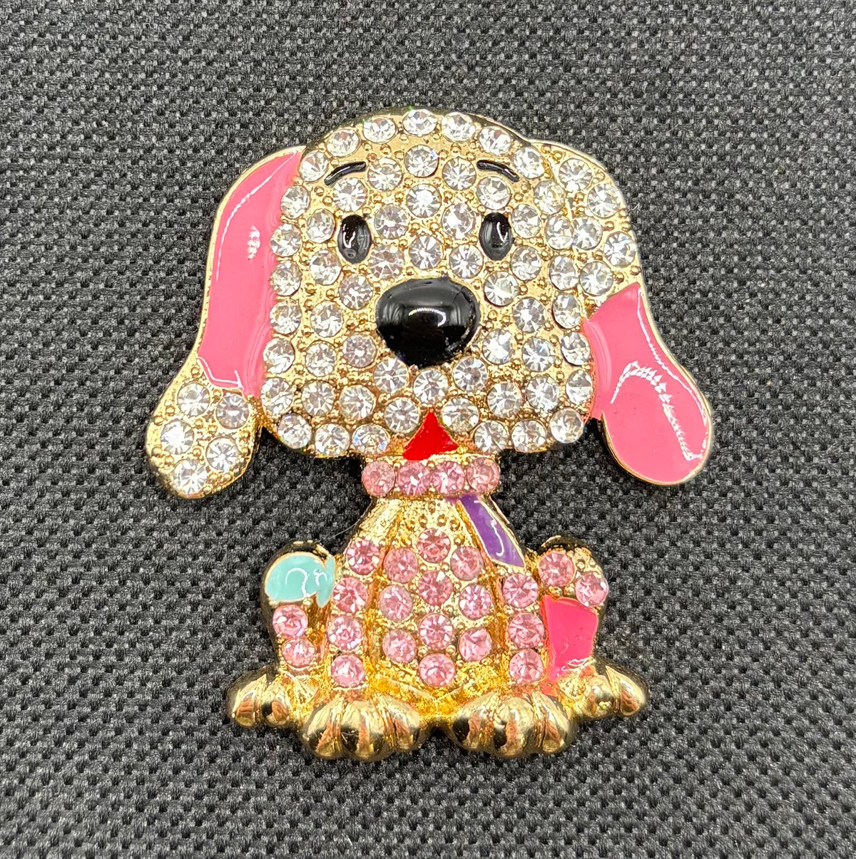Large pink crystal dog needle minder on dark fabric