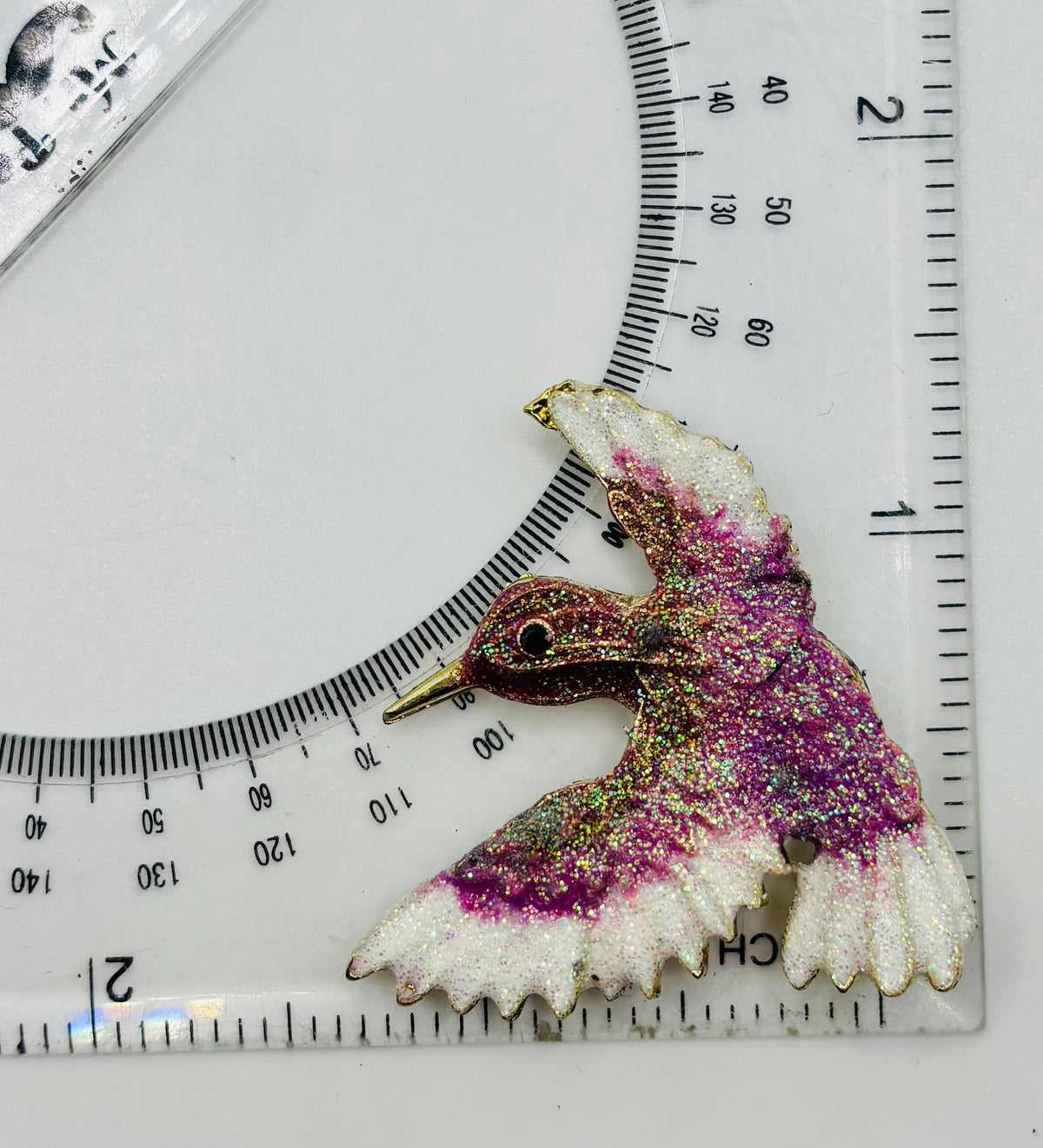 Lavender and white glittery hummingbird needle minder — ruler scale