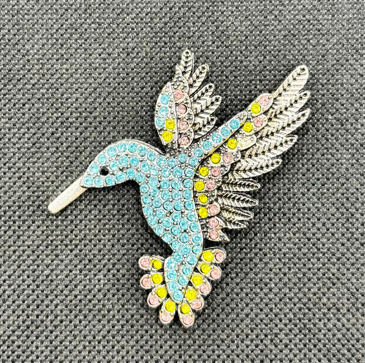 Light blue crystal hummingbird needle minder — dark fabric