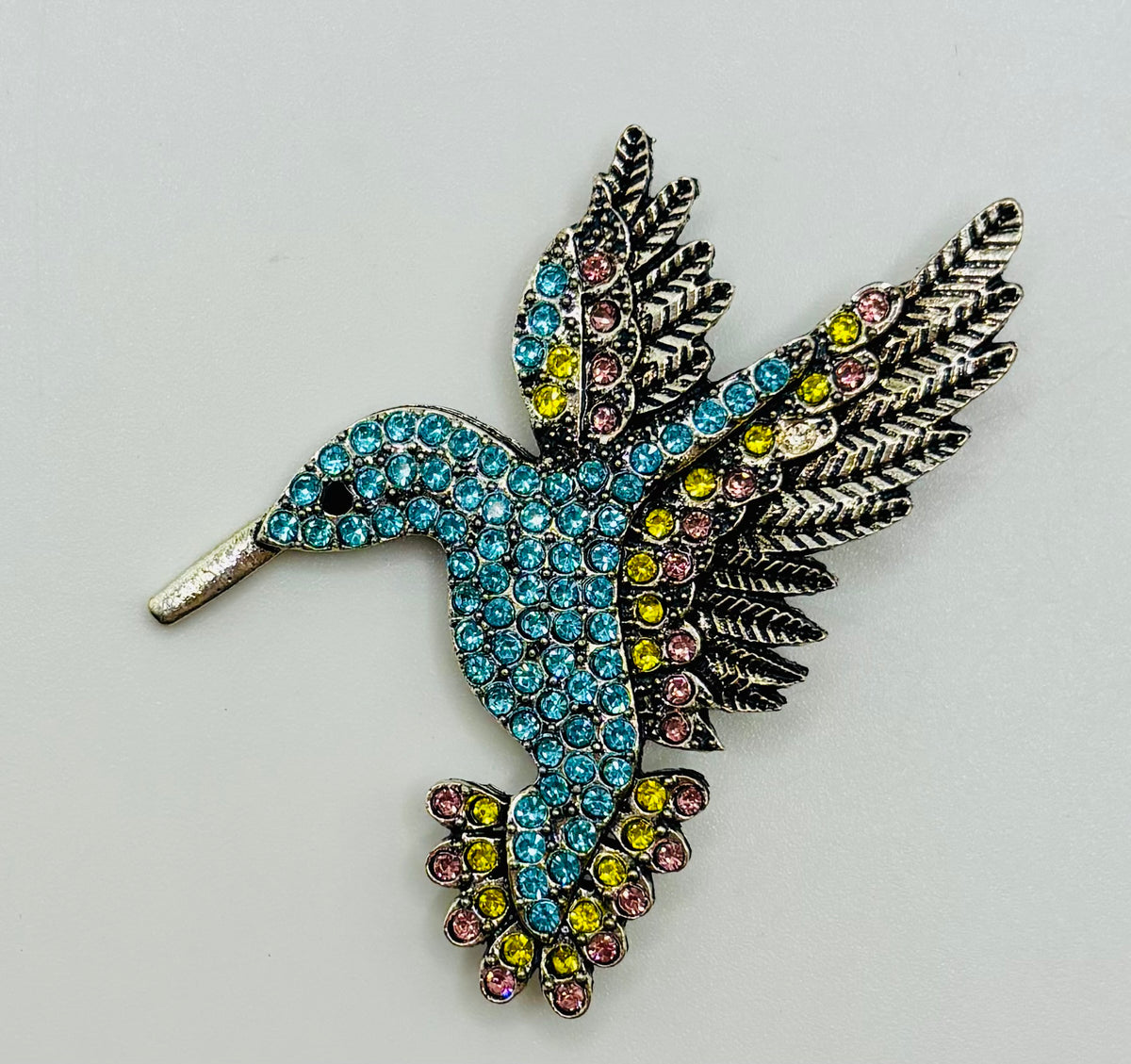 Light blue crystal hummingbird needle minder — white background