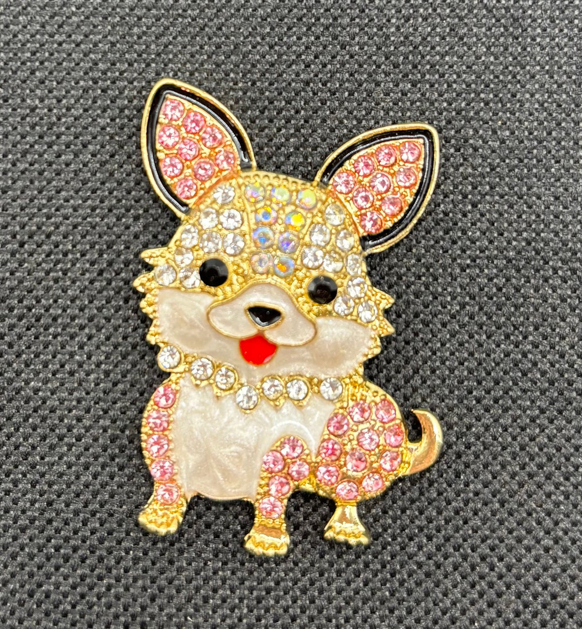 Little pink and clear crystal dog needle minder on dark fabric