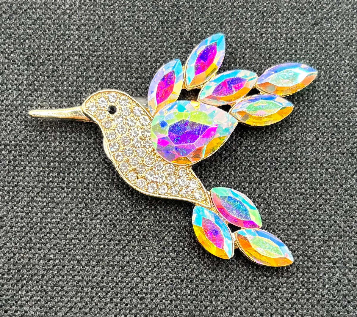 Opalescent crystal hummingbird needle minder — dark fabric