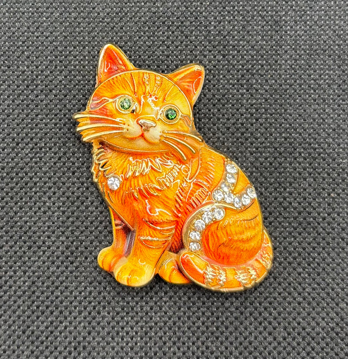 Orange tabby cat kitty needle minder on dark fabric