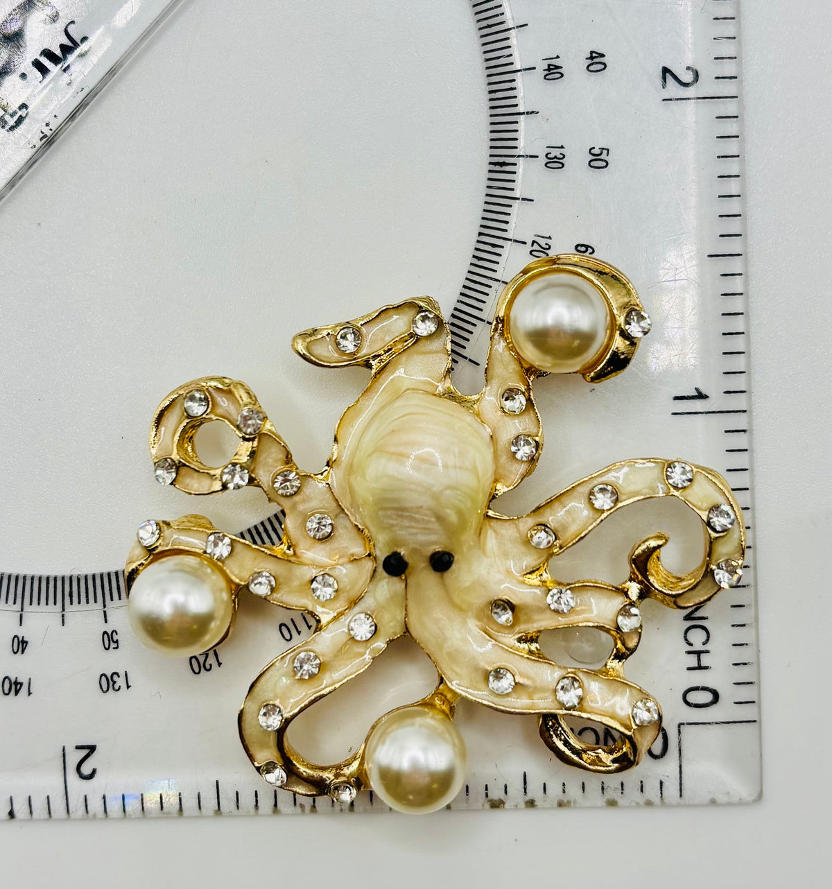 Stunning Pearl Octopus Needle Minder beside a ruler for scale