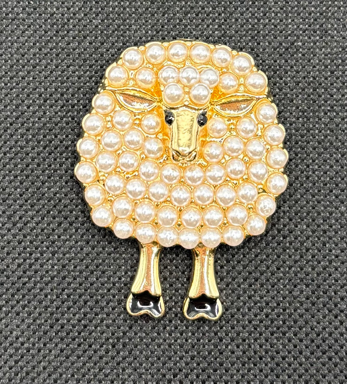 Pearl sheep needle minder on dark fabric