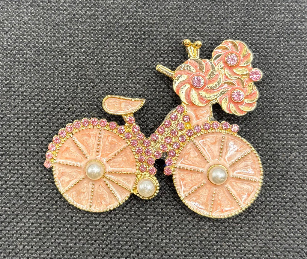 Very Pretty Pink Enamel Bicycle Needle Minder — dark fabric