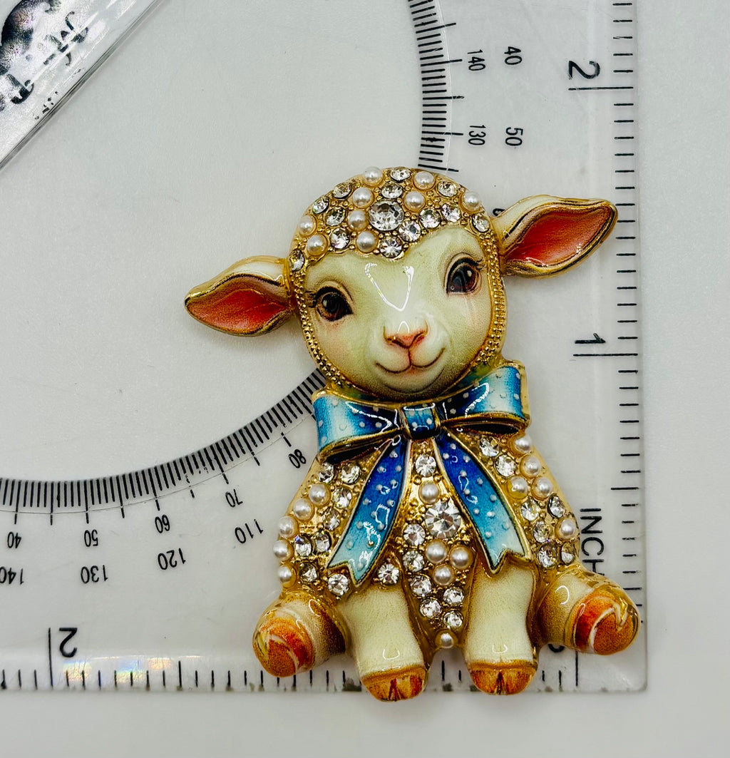 Blue bow lamb needle minder beside ruler for scale