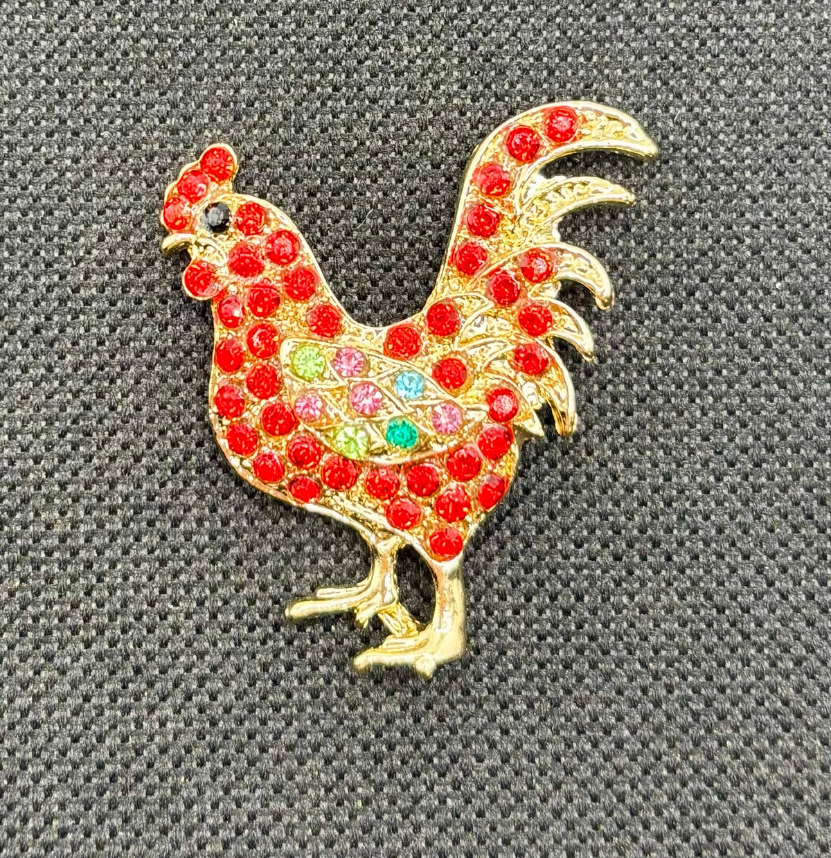 Red crystal chicken needle minder — dark fabric