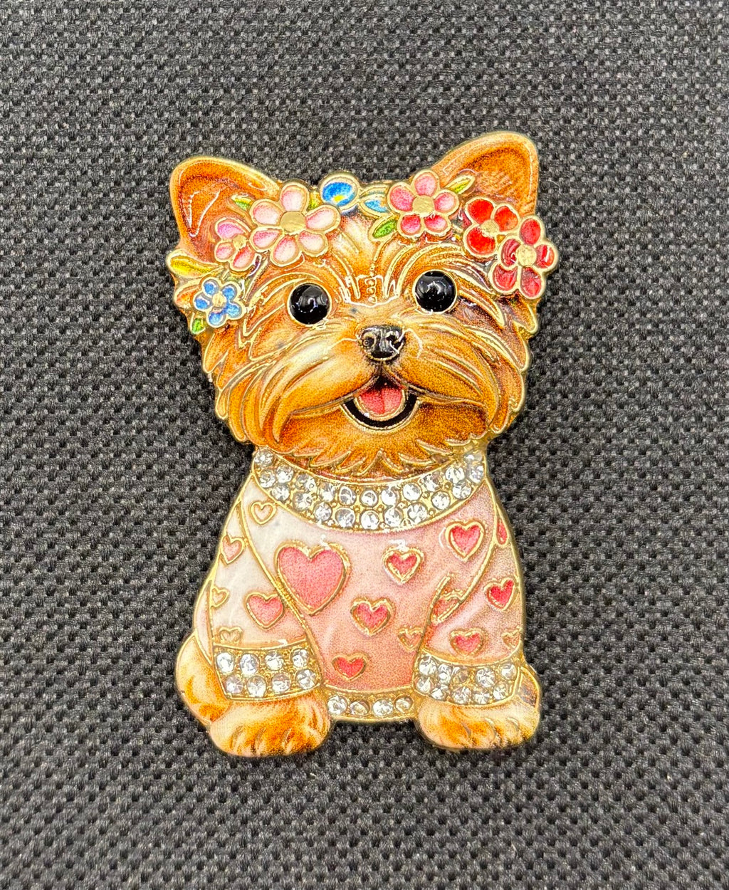 Tan dog in pink heart sweater needle minder on dark fabric